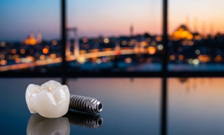 Un implant dentaire en titane et sa couronne en zircone posés sur une surface réfléchissante, avec en arrière-plan flou la ville d'Istanbul au crépuscule.