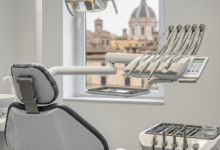 Une salle de traitement dentaire moderne et immaculée avec un fauteuil dentaire high-tech et des instruments chirurgicaux précis, dans un environnement lumineux. En arrière-plan, un paysage urbain italien flou avec une architecture classique est visible à travers une fenêtre, avec un effet bokeh.