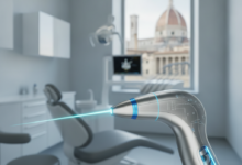 Immagine fotorealistica di un manipolo laser dentale avanzato e lucido, con un fascio di luce. Il dispositivo è in primo piano nitido, mentre lo sfondo è sfocato e mostra un moderno ambiente odontoiatrico e un vago scorcio architettonico italiano, illuminato da una luce professionale e serena. Nessun testo visibile.